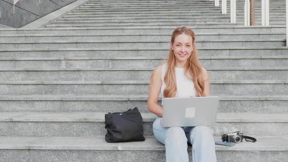 Slow motion young woman digital nomad outdoor using computer