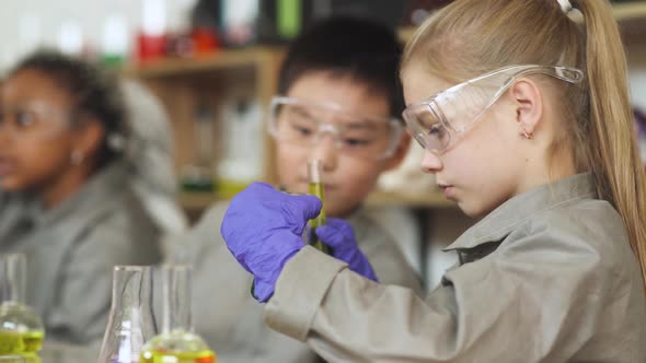 Laboratory Experience in a Chemistry Lesson Girl and Asian Boy in Protective Glasses Holding a