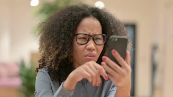 Portrait of African Businesswoman Reacting to Loss on Smartphone