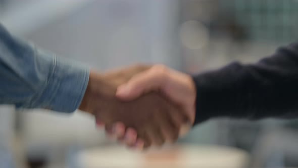 African Man and Caucasian Man Shaking Hands Close Up