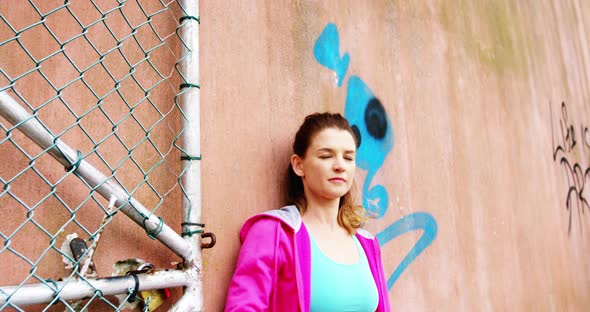 Dancer leaning against wall outside dance studio