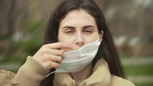 Young Woman Outdoors Wearing Medical Face Mask for Protection of Virus. Concept Coronavirus Pandemic