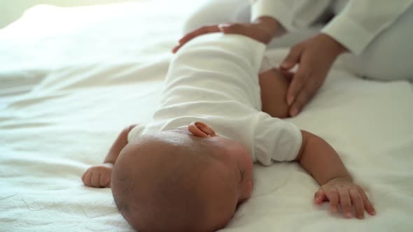 Mother Patting Baby Lying on Bed