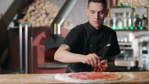 Chef Putting Red Sweet Pepper on Pizza Base