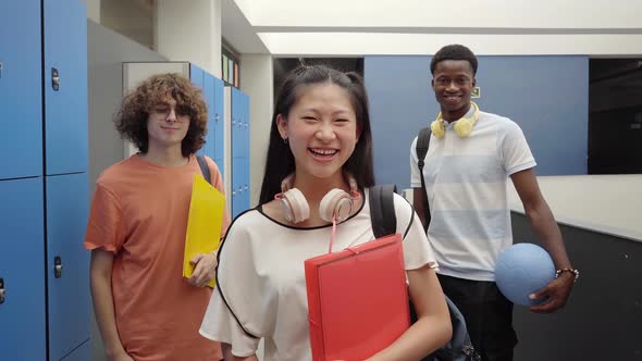 Portrait of Three Students of Different Races Looking at the Camera and Laughing at School