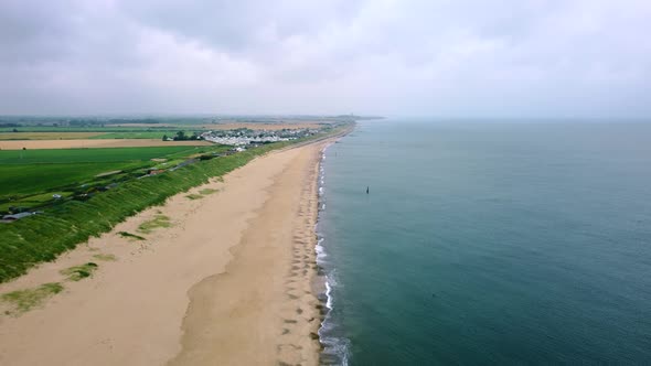 Aerial shot over a beautiful beach with no people on a cloudy early morning