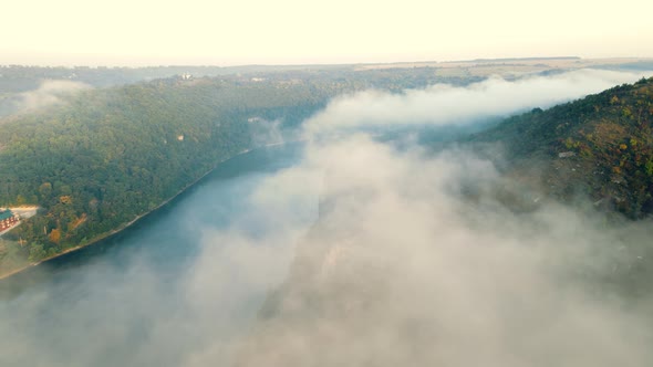 Flight Over a Wonderful Landscape of Morning Fog and a River Flowing Between the Mountains