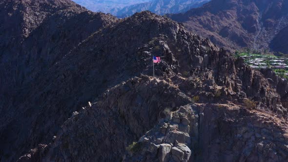 American Flag Waving in the Wind on top of a Mountain