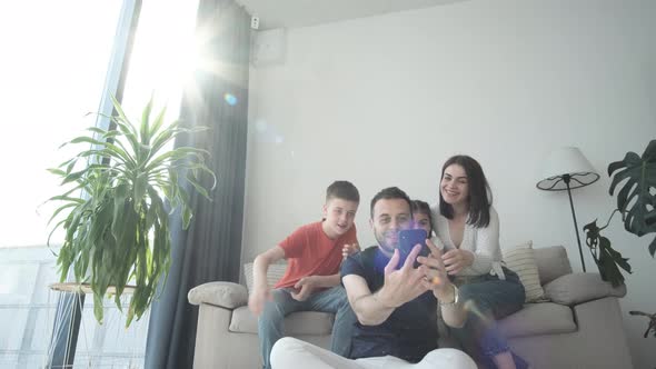 Family Taking a Selfie in the Living Room on a Sunny Day