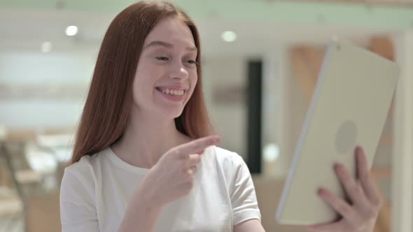 Portrait of Redhead Young Woman Doing Video Chat on Tablet