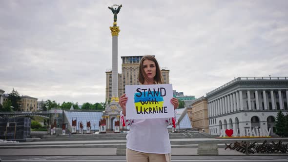 Young Woman Stands in Center of Kyiv Holding Antiwar Poster