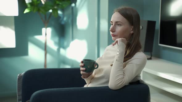 Woman at Home Sitting on Chair Relaxing Drinking Coffee or Tea