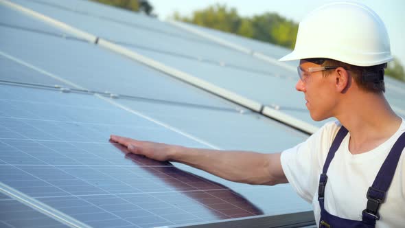 Young Engineer is Checking the Operation of Sun and Cleanliness of Photovoltaic Solar Panels