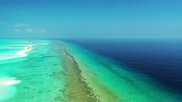 Daytime fly over copy space shot of a white paradise beach and aqua blue ocean background in high re