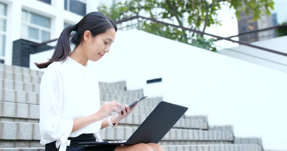 Business woman use of notebook computer in city