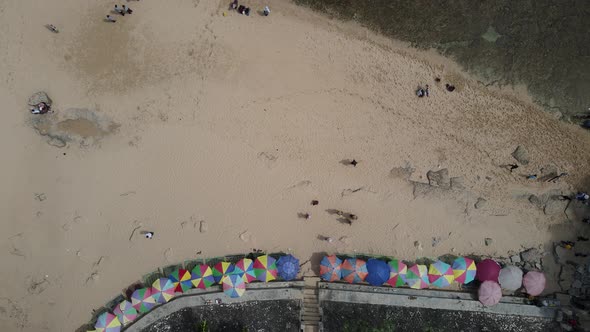 Aerial view of tropical beach in Gunung kidul, Indonesia with green and rocky cliff.