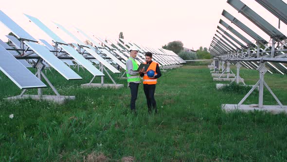 Two Young Caucasian Engineers Learn How To Build a Laptop Plan for Outdoor Solar Panels.