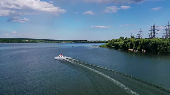 Motor boat going fast on water. Aerial drone view of boat sailing across river