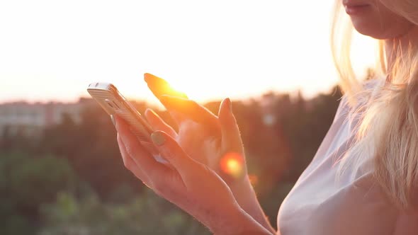 Woman Uses Smartphone on the Sunset. Slow Motion