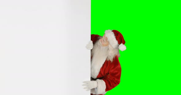 Santa claus hiding behind green screen
