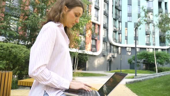 Young Woman Typing on Keyboard of Laptop Businesswoman Using Digital Tablet Outside on Modern