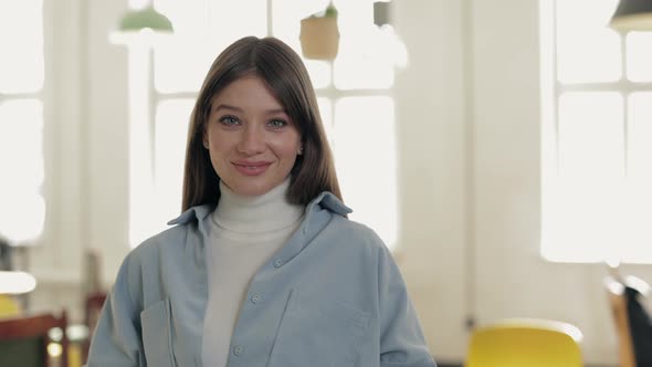 Charming Brunette with Blue Eyes Standing at Local Cafe