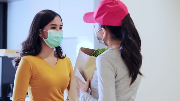 Asian woman face mask at home and deliver woman wearing face mask handling bag