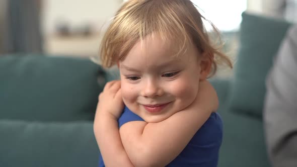 Portrait of a Happy Blondie Little Boy Laughing and Hugging Himself