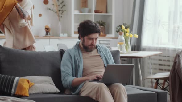 Happy Married Couple Fighting with Pillows at Home