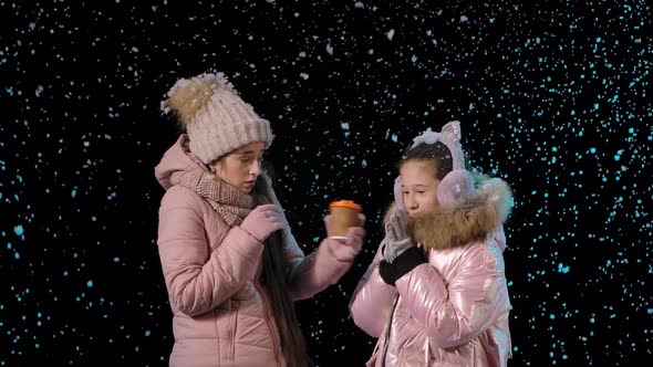 The Frozen Mother and Daughter Keep Warm with a Hot Drink. A Woman and a Little Girl Rejoice in the