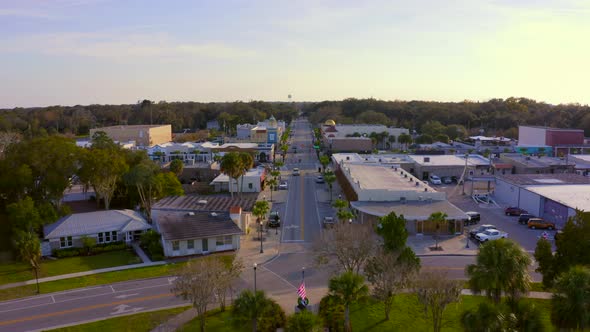 Flying Over Trees and Towards the Main Road of a Small Town in Florida