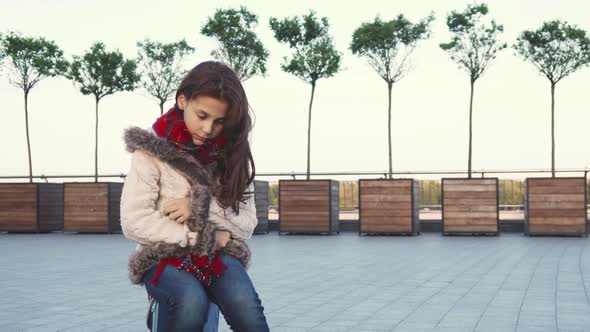 A Sweet Girl Sits in the Middle of the Street and Being Sad alt