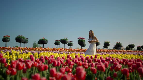Laughing Girl with Camera Running in Tulip Field
