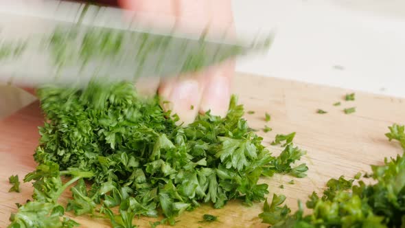 Cutting vegetable parsley plant on smaller pieces with knife 4K 3840X2160 UltraHD  footage - Petrose