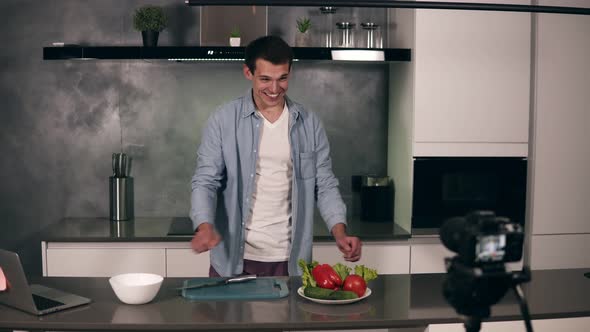 Young Man in Casual Clothes Leads a Culinary Blog and Records Video in Grey Kitchen