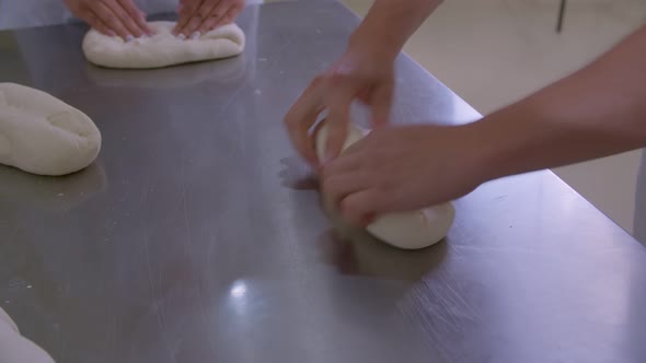 Closeup of Dough Kneaded By Baker on a Wooden Board Sprinkled with Flour