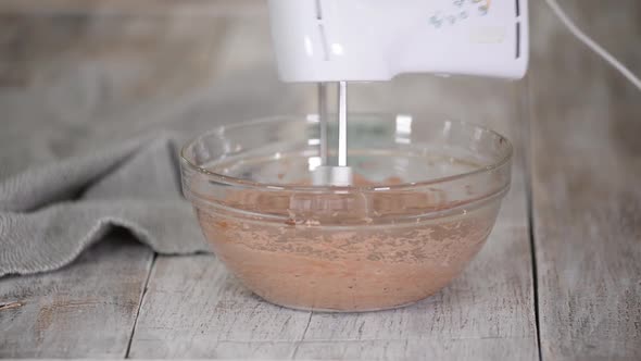 A Baker with Hand Mixer Whip Up Some Chocolate Buttercream Frosting