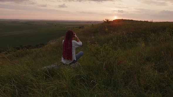 Girl Sits on the Stone and Starts Shooting on Her Camera