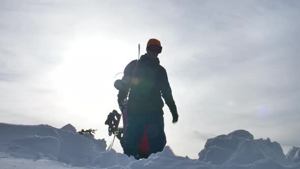 Two Snowboarders Hiking Towards And Away From Camera Silhouette Bright Sunny Day