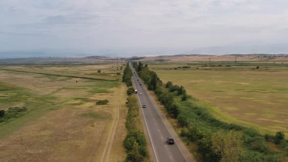 Aerial Drone Shot of Armenian Fields and Cars on the Road in Summer