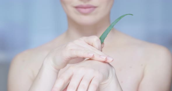 Woman Moisturizing Palm With Aloe Vera