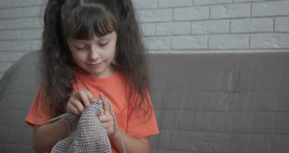 Child Knitting on Sofa