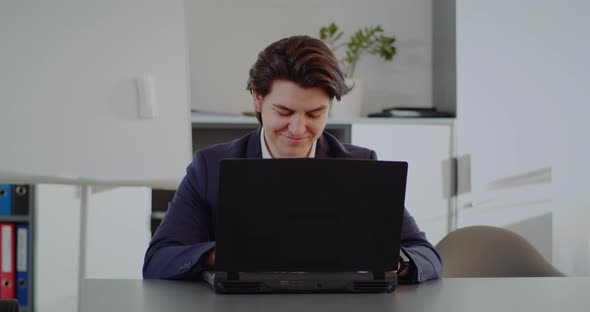 Positive Man In Office Working on Laptop Computer