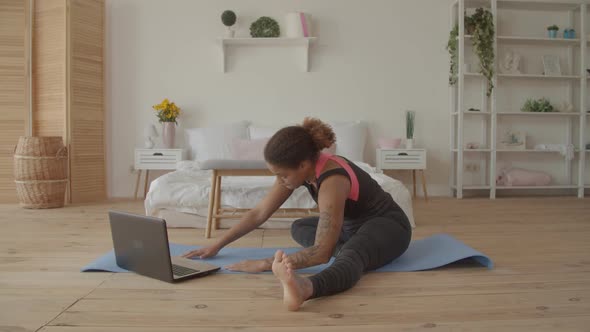 Woman Exercising Watching Fitness Video on Laptop