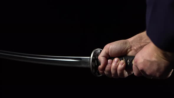 Katana in Hand Close-up Black Background