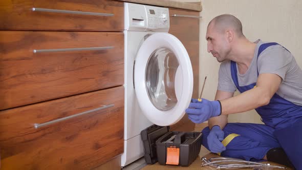 Plumber repairing a washing machine.