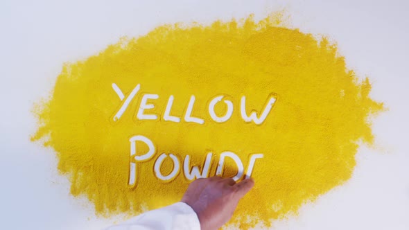 Hand Writes On Turmeric Yellow Powder