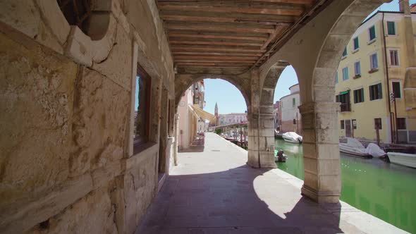 Scroll Under the Arcades of Chioggia in Italy