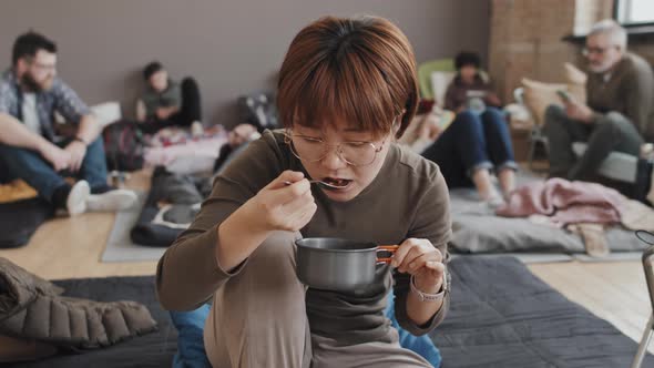 Woman Eating Food in Refuge
