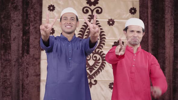 Two Muslim men showing victory sign
